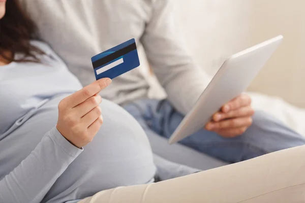 Pregnant couple shopping online with digital tablet and credit card. — ストック写真