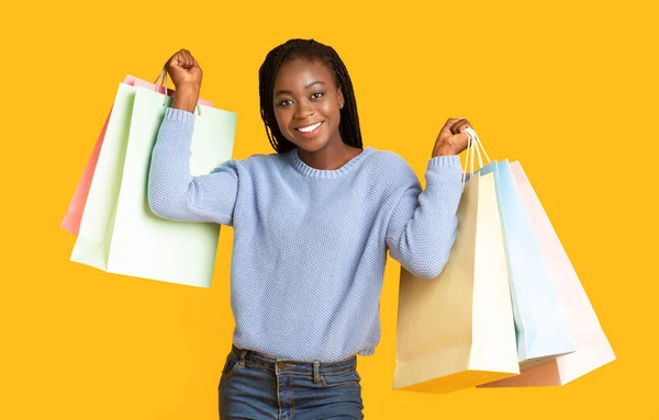 Happy black girl raising hands up with purchases — ストック写真