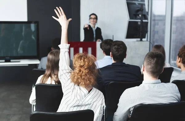 Tengo una pregunta. Empresaria levantando la mano en seminario — Foto de Stock