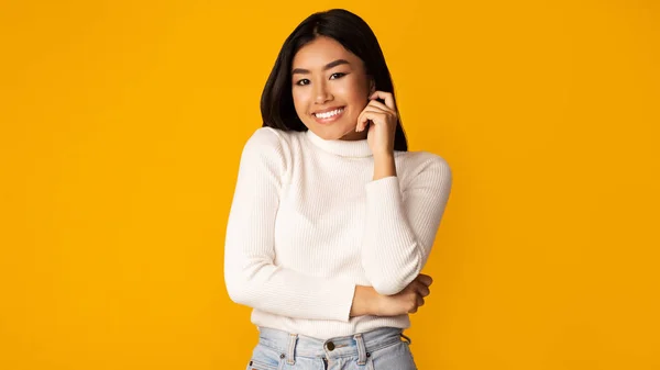 Fiduciosa ragazza asiatica posa su sfondo giallo — Foto Stock