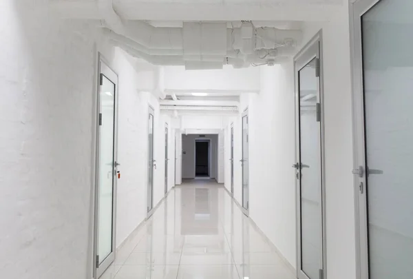 Deep hospital corridor with closed doors in chambers — Stock Photo, Image