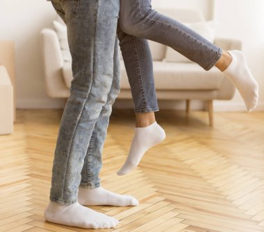 Siyah adam kaldıran eş, hareket eden kutuların arasında duruyor.