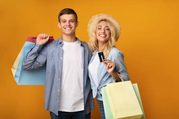 Casal de turistas com sacos de compras e cartão de crédito — Fotografia de Stock