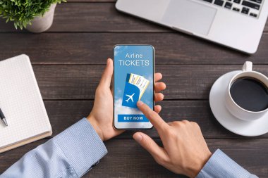 Akıllı telefondan havayolu biletlerini almak için başvuru kullanan bir adam
