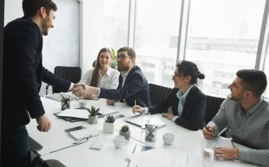 Memnun İK yöneticileri başvuran kişiyle tokalaşıyor