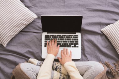 Açık dizüstü bilgisayarda siyah boş ekranla yazan kadın.