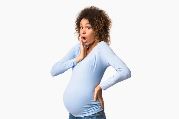 Shocked african-american pregnant lady posing in studio — Stock Photo, Image