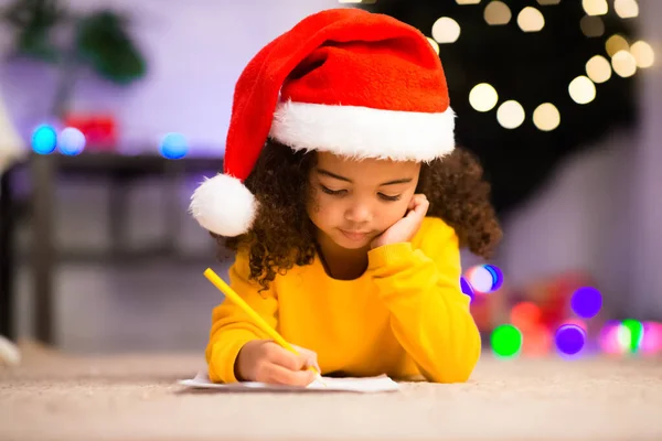 Focada menina escrevendo carta para Papai Noel — Fotografia de Stock