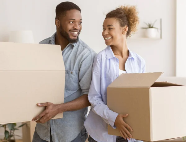 Svarta par som håller rörliga lådor stående back-to-back i nytt hem — Stockfoto