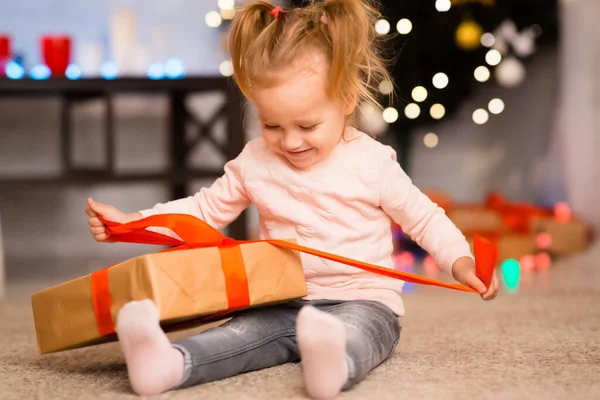 Menina feliz abrindo presente de Natal em casa — Fotografia de Stock