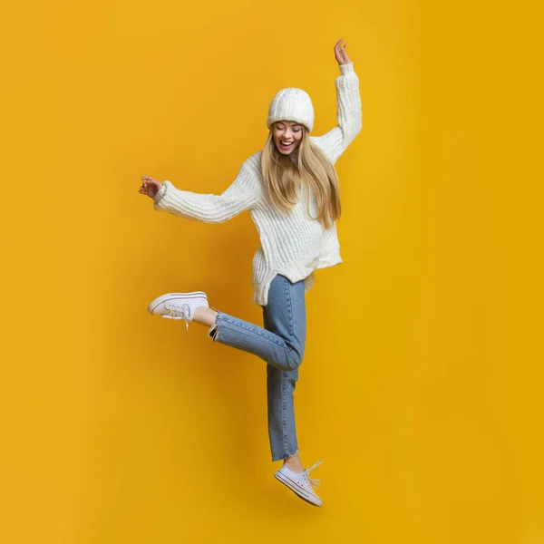 Cheerful blonde girl dancing and jumping in the air — Stock Photo, Image