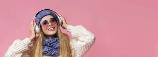 Roztomilé zimní dívka těší hudbu s moderními bezdrátovými sluchátky — Stock fotografie