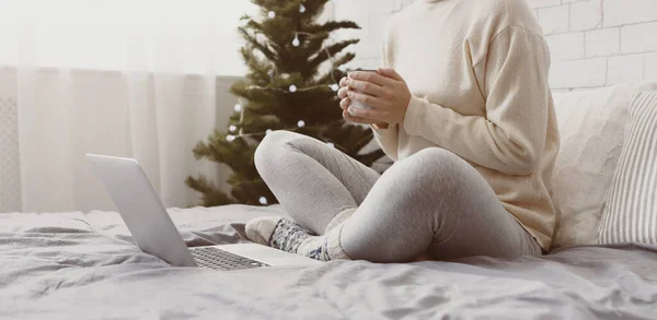 Woman drinking hot chocolate and looking at laptop — Stock Photo, Image