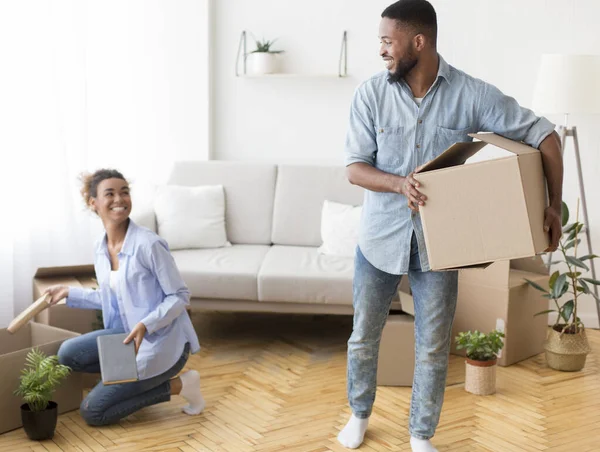 Glada svarta par packa upp flyttkartonger inomhus — Stockfoto