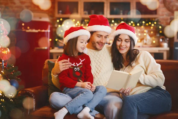 Portrait of friendly family reading book on Christmas evening — Stock Photo, Image