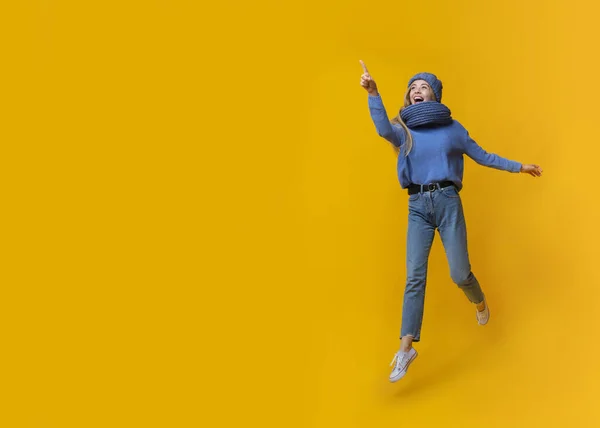 Érzelmi téli lány rámutatva másolás tér felett sárga háttér — Stock Fotó