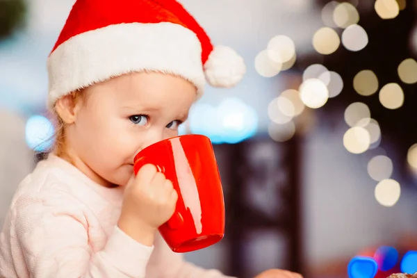 Niña disfrutando de chocolate caliente cerca del árbol de Navidad —  Fotos de Stock