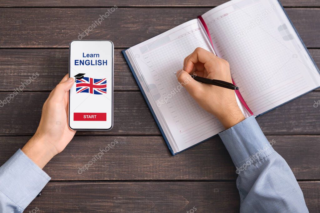 Man using smartphone with Learning English app and writing notes