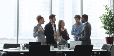 Çeşitli yönetim ekibi konferans odasında konuşuyor.