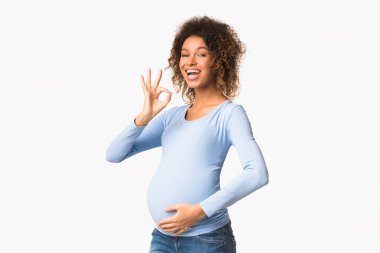 Heyecanlı afro hamile kadın Tamam hareketi gösteriyor