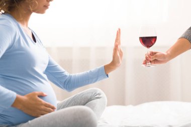 Alcohol prohibited. Expectant woman refusing to drink wine clipart