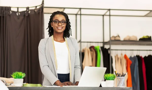 Skräddarsydd dam arbetar på laptop stående i egen Dressmaking Studio — Stockfoto