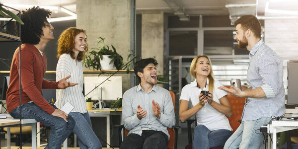 Group of colleagues laughing together during coffee break