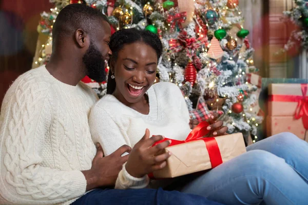 Radostná černošky žena obdrží vánoční dárek od svého milujícího manžela — Stock fotografie
