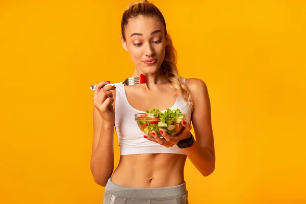 Mulher Esportiva Comer Salada Vegetal Holding Bowl em pé, Estúdio tiro — Fotografia de Stock