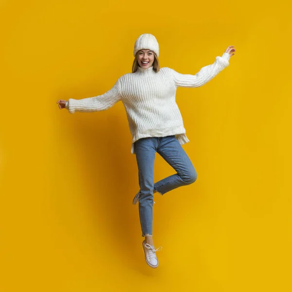 Сміється зимова дівчина стрибає на одній нозі — стокове фото
