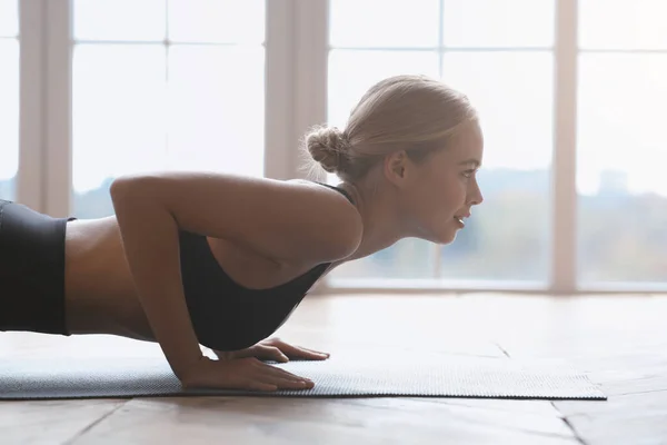 Половина тела девушки йоги, занимающейся на деревянном полу — стоковое фото