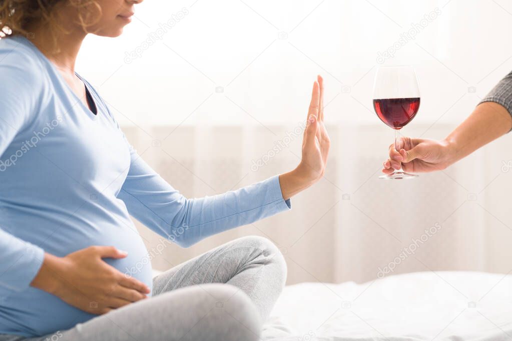 Alcohol prohibited. Expectant woman refusing to drink wine