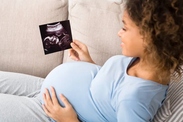 Femme enceinte afro-américaine tenant une échographie à la maison — Photo