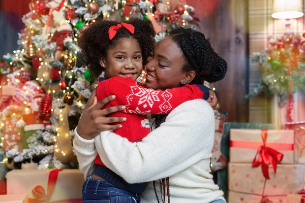 Bela mãe e filha africana abraçando perto da árvore de Natal — Fotografia de Stock