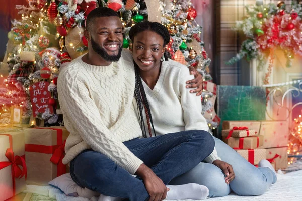 Χαρούμενο μαύρο ζευγάρι που ποζάρει κοντά στο χριστουγεννιάτικο δέντρο, γιορτάζοντας μαζί τα Χριστούγεννα — Φωτογραφία Αρχείου