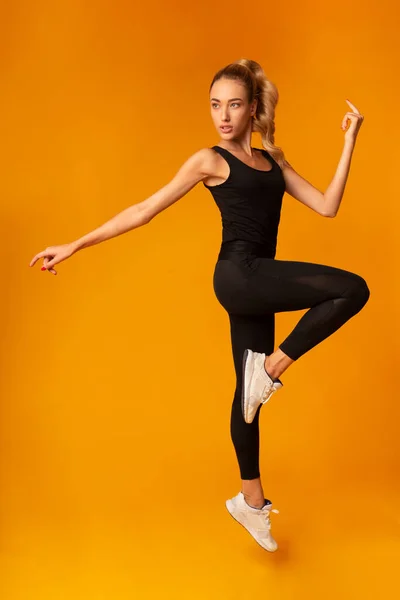 Fit Lady springen tijdens de training over gele achtergrond — Stockfoto