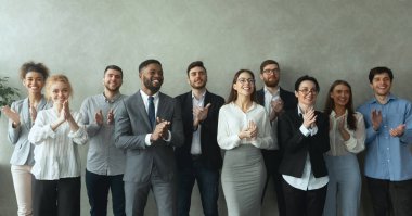 Bir grup iş adamı, patronu tebrik etmek için el çırpıyor.