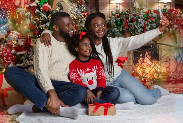 Mulher negra feliz tomando selfie de Natal com seu marido e filha — Fotografia de Stock