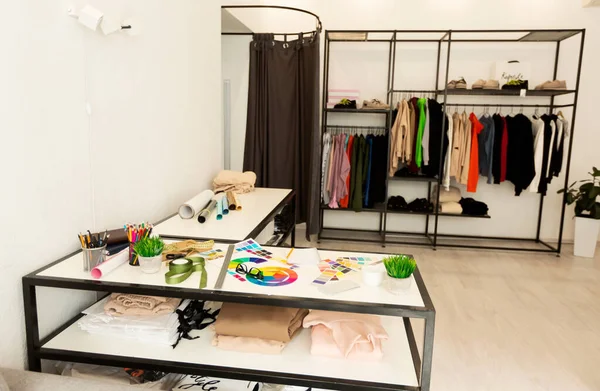 Kleermakers Atelier achtergrond met werkplek, kleding hangers en naaigereedschap — Stockfoto