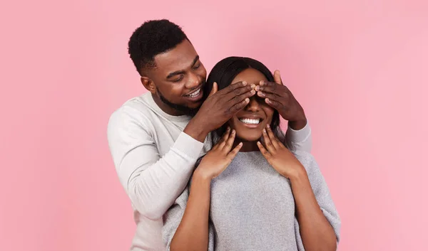 Zwarte man maken verrassing voor zijn vrouw, bedekken haar ogen — Stockfoto