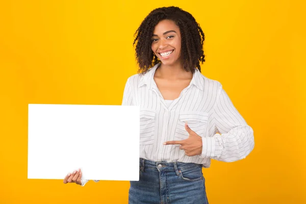 Αφροαμερικανή που δείχνει το λευκό χαρτί. — Φωτογραφία Αρχείου