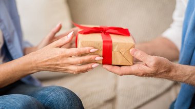 Noel hediyesini takdim ediyorum. Yaşlı çift Noel hediyelerini değiş tokuş ediyor.