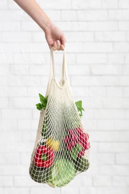 Kadın elinde taze ve temiz sebzelerle birlikte eko pamuk alışveriş torbası