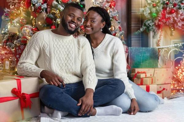크리스마스 트리 근처 바닥에 앉아 있는 행복 한 흑인 커플의 사진 — 스톡 사진