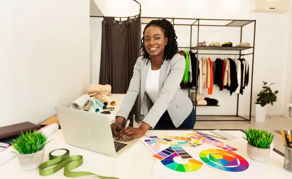 Afro Tailor met behulp van laptop werken aan naaipatroon in Atelier — Stockfoto