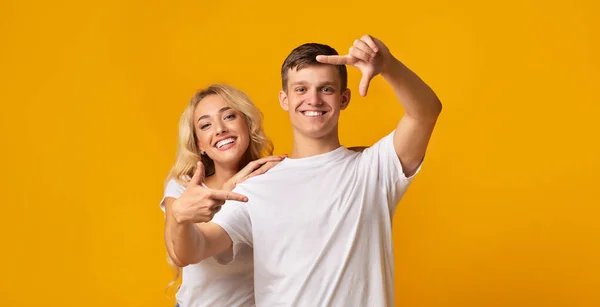 Alegre millennial pareja hacer marco con los dedos, divertirse juntos —  Fotos de Stock