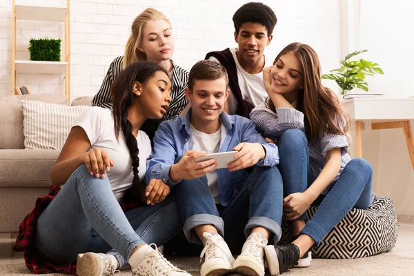 Tiener guy tonen nieuwe video op mobiele telefoon naar vrienden — Stockfoto