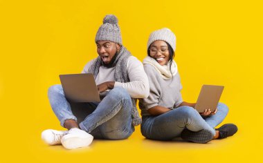 Kış adamı ve kız online bahis oynuyorlar, laptop kullanıyorlar.