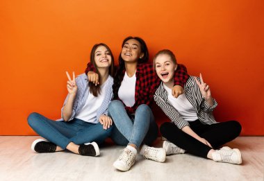 Kameraya gülümseyen ve barış jestleri yapan pozitif kız arkadaşlar