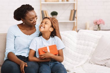 Siyah kız annesinin yanında oturuyor.